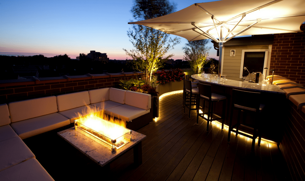 Fire table and outdoor kitchen at dusk.